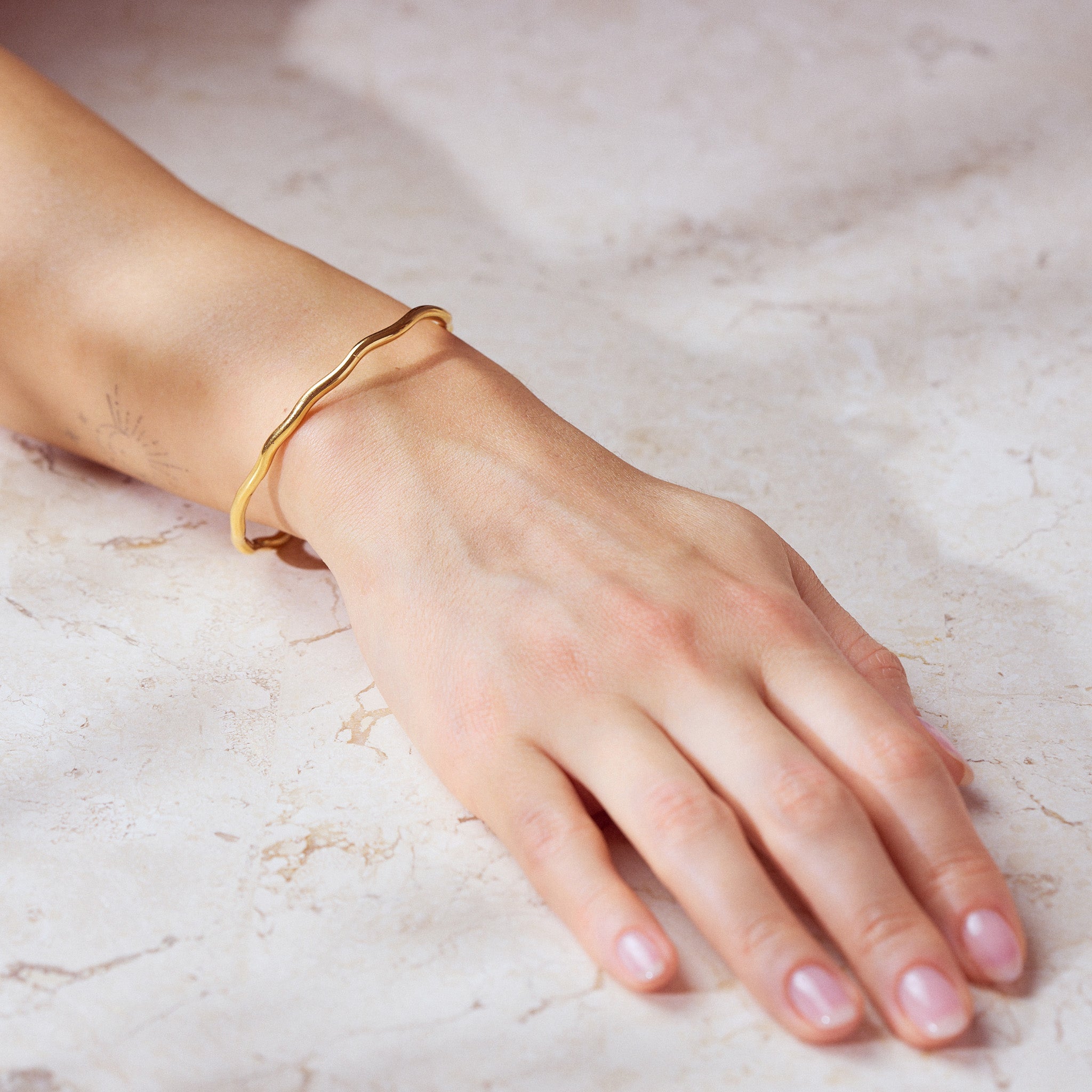 Capetown Armreif: Glanz für dein Handgelenk. Vielseitig kombinierbar mit anderen Armbändern oder Reifen. Ein unverzichtbares Accessoire. 18k vergoldet und wasserfest.