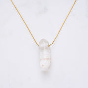 Bild einer eleganten Crystal-Halskette, die für positive Energie und die Reinigung von Geist und Seele steht. Jeder Naturstein ist einzigartig und variiert in Farbe und Form. Die Kette ist ein stilvolles Accessoire und ein echter Hingucker.