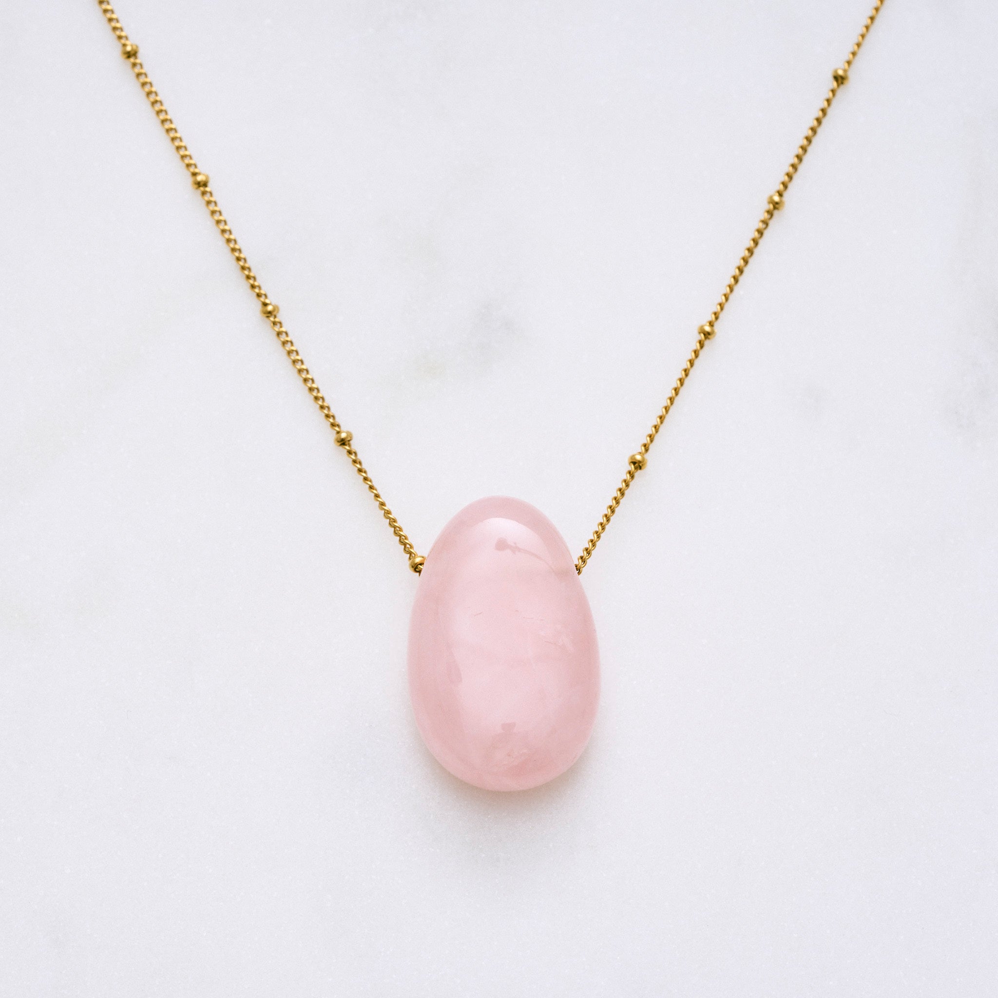 Bild einer zarten Rosy-Halskette mit einem Rosenquarz-Anhänger, der als Stein der Herzen bekannt ist. Jeder Naturstein ist einzigartig in Farbe und Form. Diese Kette symbolisiert Kraft und Wärme für die Seele und ist gleichzeitig ein stilvolles Accessoire und Hingucker.