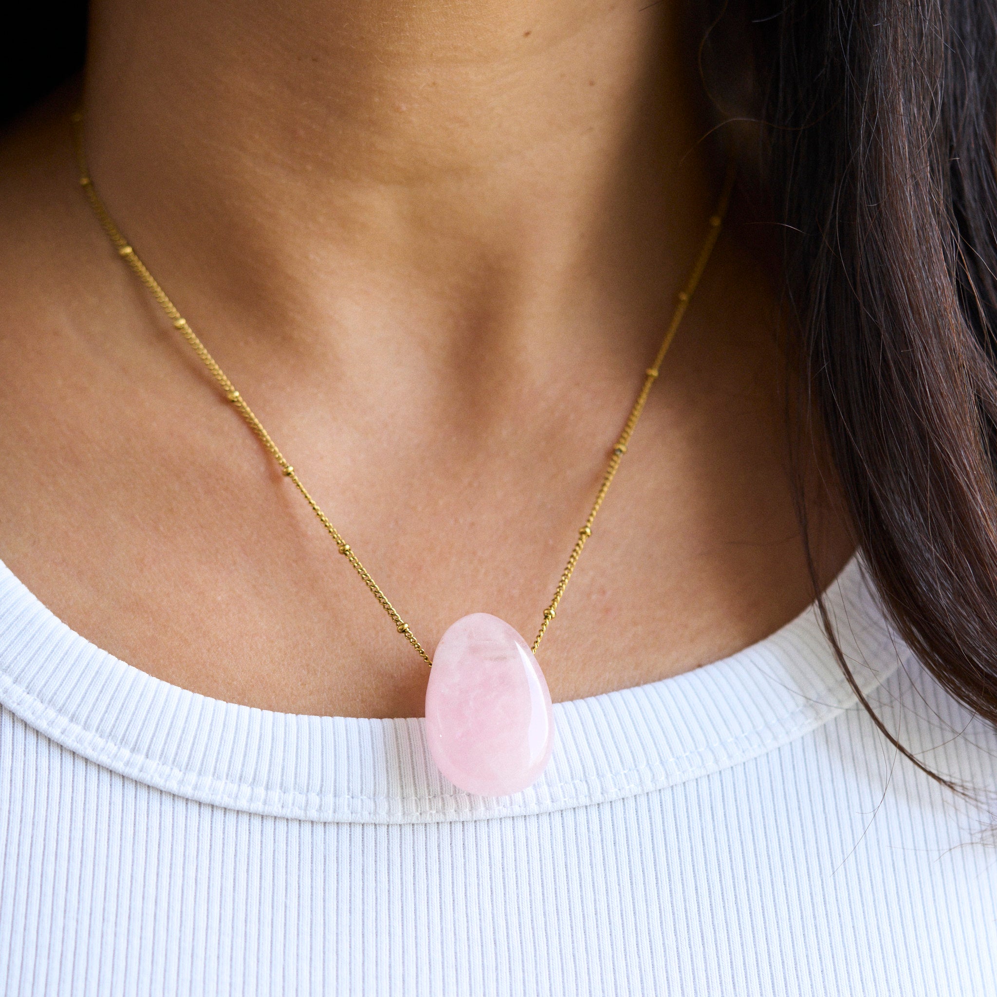 Bild einer zarten Rosy-Halskette mit einem Rosenquarz-Anhänger, der als Stein der Herzen bekannt ist. Jeder Naturstein ist einzigartig in Farbe und Form. Diese Kette symbolisiert Kraft und Wärme für die Seele und ist gleichzeitig ein stilvolles Accessoire und Hingucker.