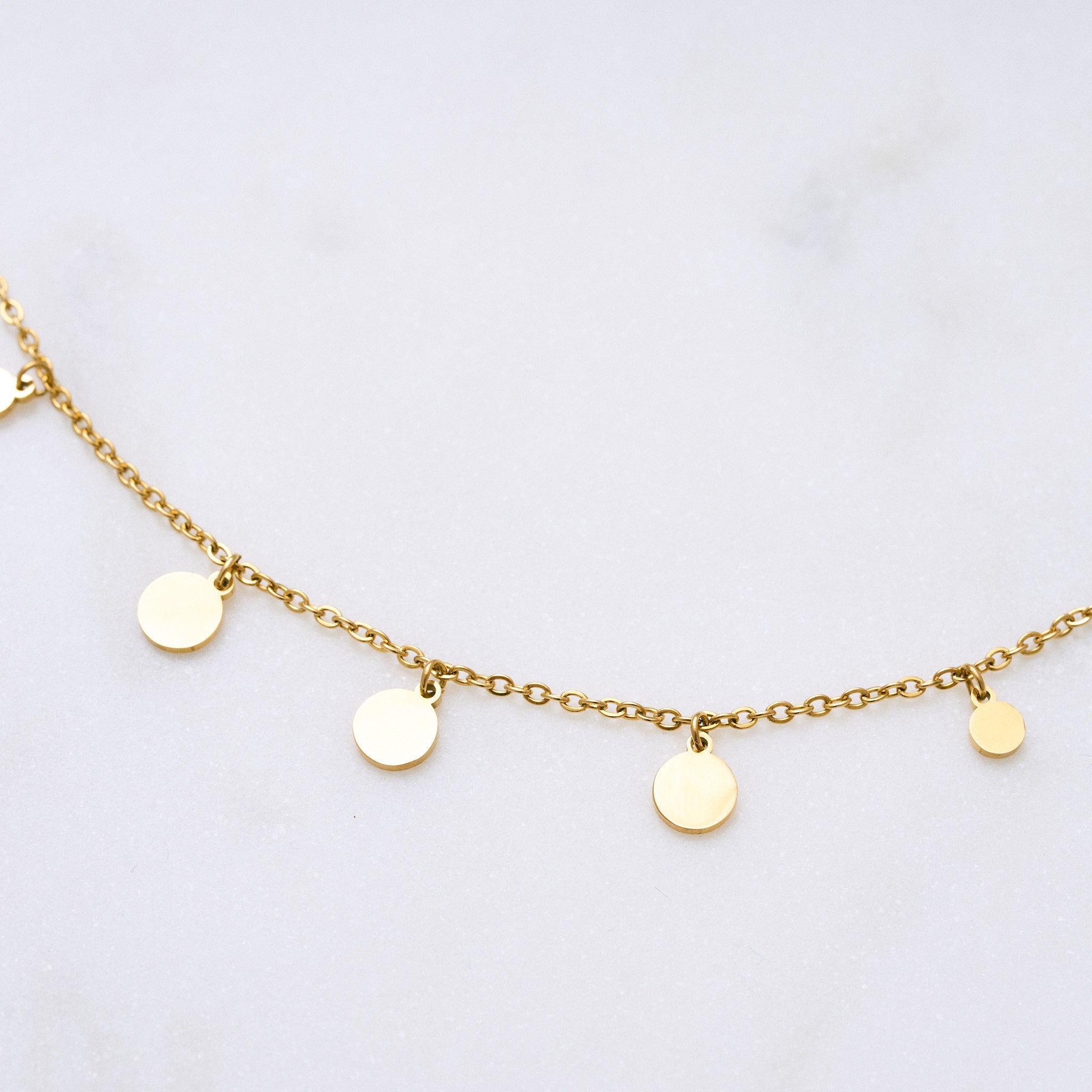 Eine filigrane Halskette mit schimmernden Plättchen, die das Licht reflektieren und ideal für vielseitige Looks von morgens bis abends geeignet ist – perfekt solo oder in Kombination mit anderen Schmuckstücken.