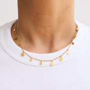 Eine filigrane Halskette mit schimmernden Plättchen, die das Licht reflektieren und ideal für vielseitige Looks von morgens bis abends geeignet ist – perfekt solo oder in Kombination mit anderen Schmuckstücken.