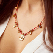 "So bunt und fröhlich wie diese Kette mit ihren vielen kleinen Charms und Perlen verbindet sie Sonne, Strand und Lachen. Fühle dich jeden Tag, als würde die Sonne auf deinen Körper strahlen! Diese Kette eignet sich wunderbar für weitere Layering-Styles. Probier doch mal die Snake-Ketten als Kombination dazu aus! Eine Halskette für Frauen, 18k vergoldet und wasserfest."