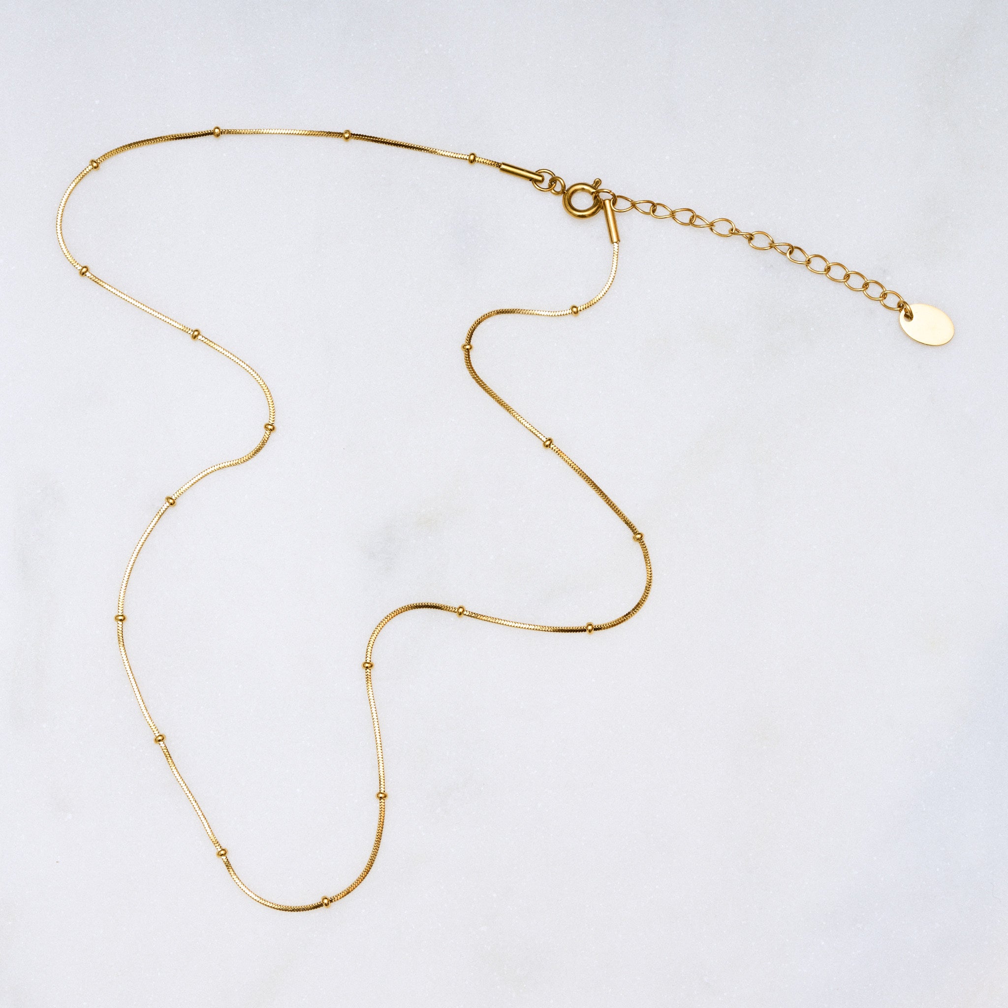 Für diejenigen, die es filigran und unaufdringlich mögen, ist die Dot Halskette die perfekte Wahl! Die kleinen Kugeln sitzen fest und glitzern an deinem Hals. Sie lässt sich gut mit anderen Ketten kombinieren und auch mit einem Anhänger ist sie eine ideale Wahl. Eine Halskette für Frauen, 18k vergoldet und wasserfest.