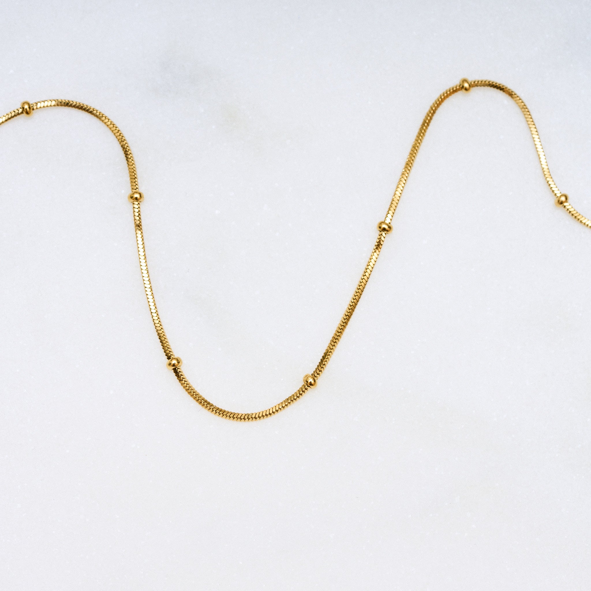 Für diejenigen, die es filigran und unaufdringlich mögen, ist die Dot Halskette die perfekte Wahl! Die kleinen Kugeln sitzen fest und glitzern an deinem Hals. Sie lässt sich gut mit anderen Ketten kombinieren und auch mit einem Anhänger ist sie eine ideale Wahl. Eine Halskette für Frauen, 18k vergoldet und wasserfest.