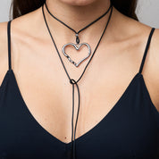 Trendige silberne Herzkette mit Schnurband und dem Schriftzug ‚LOVE‘. Der 90er-Jahre-inspirierte Schmuck bietet eine verspielte und kraftvolle Note, mit flexibler Verschlussmöglichkeit durch Knoten oder Schlaufe.