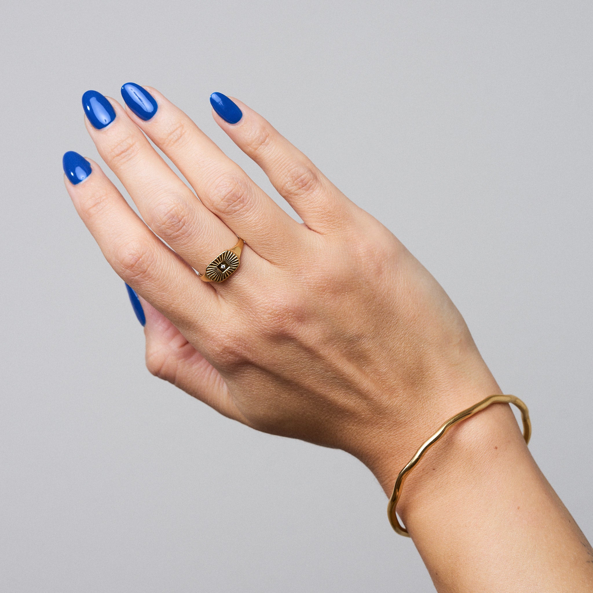 Beam Ring: Filigraner Siegelring mit sonnenstrahlenartigen Einkerbungen und einem kleinen Glasstein in der Mitte. Ein dezentes Statement für Liebhaber
zarter Schmuckdesigns.